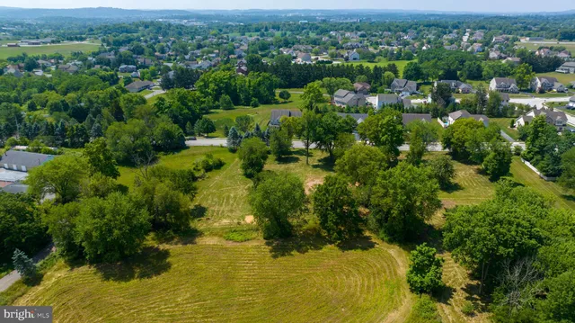 an aerial view of residential houses with outdoor space and trees