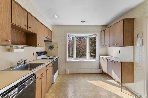 a kitchen with granite countertop a sink and a stove top oven