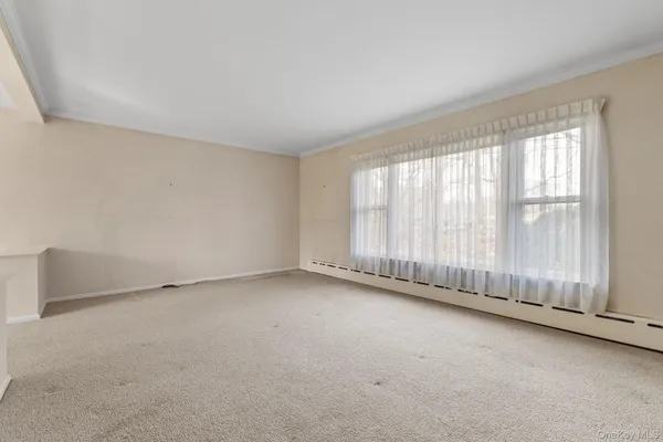 a view of a livingroom with an empty space and a window