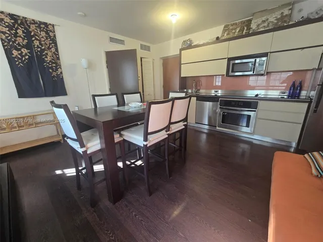 a kitchen with stainless steel appliances wooden floor and a counter top space