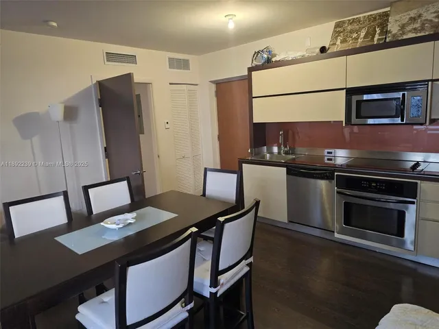 a kitchen with stainless steel appliances granite countertop a stove refrigerator and microwave