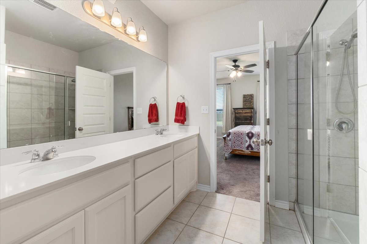 5408 Vanner Path Georgetown, TX 78626 - Photo 18 of 34 Bathroom featuring a dual vanity with white countertops, integrated sinks, and chrome faucets
