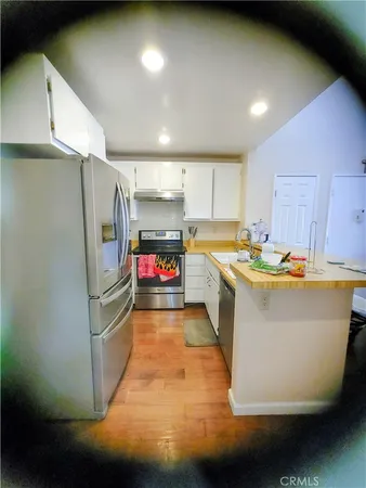 a view of a kitchen with kitchen island a stove a sink and a refrigerator