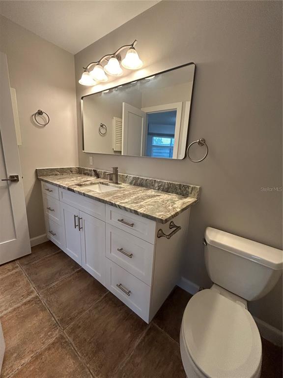 7006 Midnight Pass Road Sarasota, FL 34242 - Photo 7 of 12 a bathroom with a granite countertop toilet sink and mirror