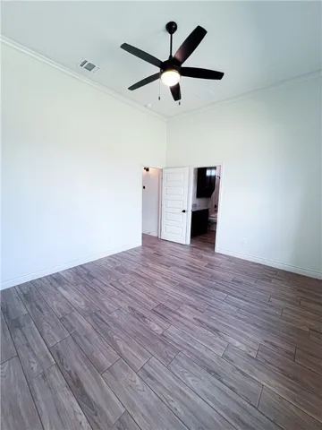 a big room with wooden floor and a ceiling fan