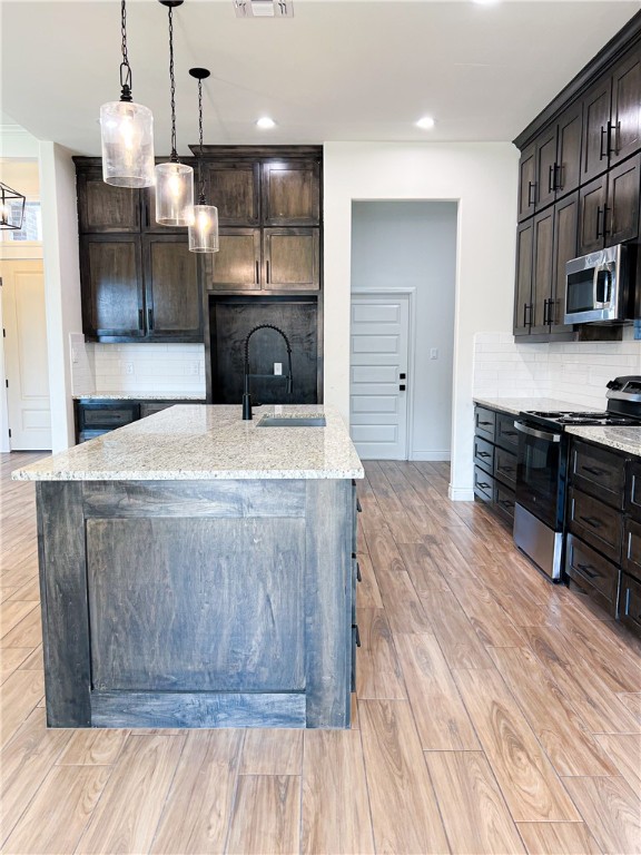 6918 Pacific Way Corpus Christi, TX 78414 - Photo 4 of 34 a kitchen with stainless steel appliances kitchen island granite countertop a stove a sink and a microwave