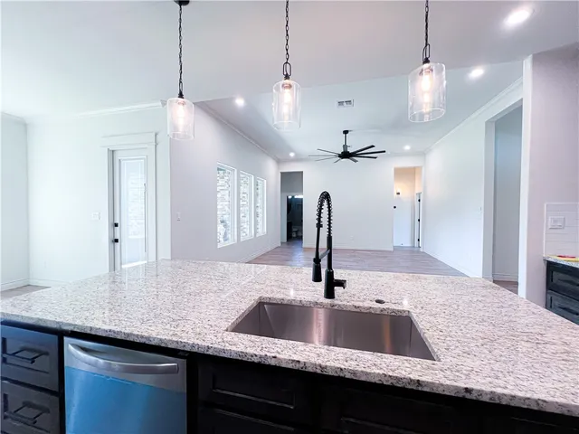 a kitchen with granite countertop a sink a counter and wooden floor