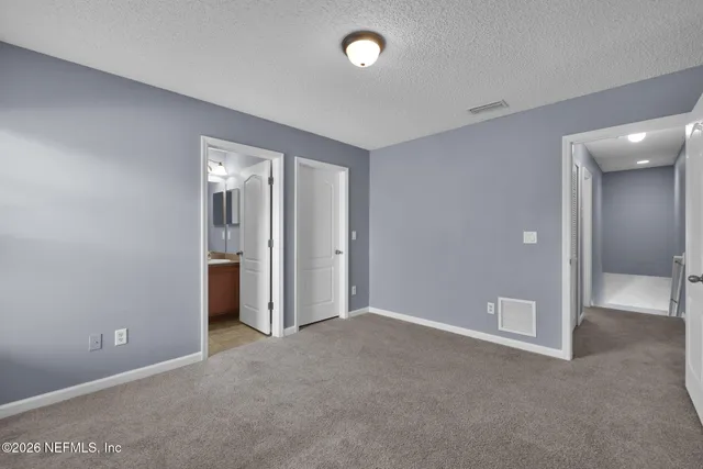 an empty room with windows and closet