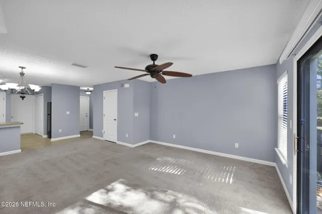 a view of a livingroom with a ceiling fan and window