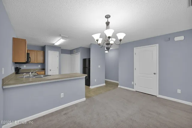 a view of a dining room with furniture and chandelier