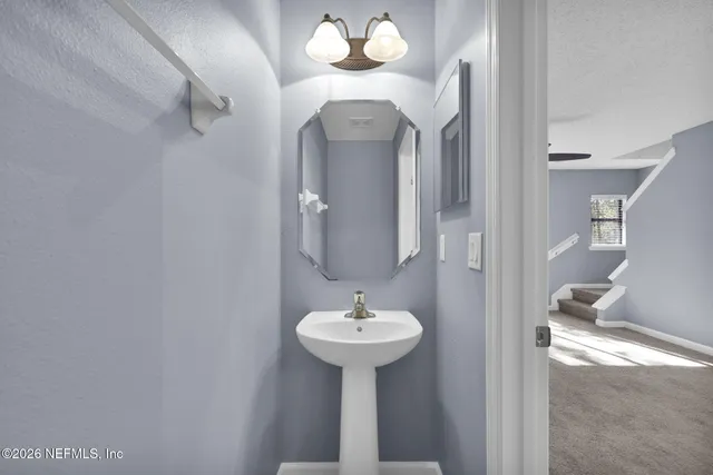 a view of a kitchen with a sink stainless steel appliances and chandelier