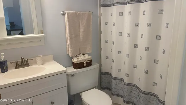 a bathroom with a sink a toilet and shower curtain