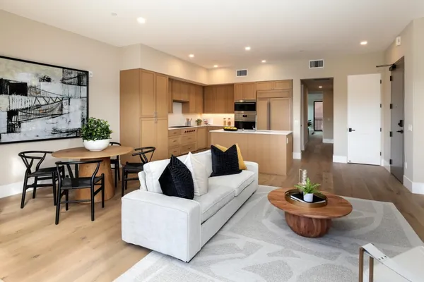 a living room with furniture and a dining table with kitchen view