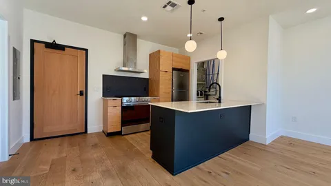a view of kitchen and hall with wooden floor
