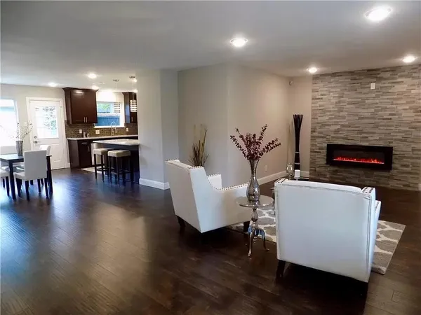 a living room with furniture a fireplace and wooden floor