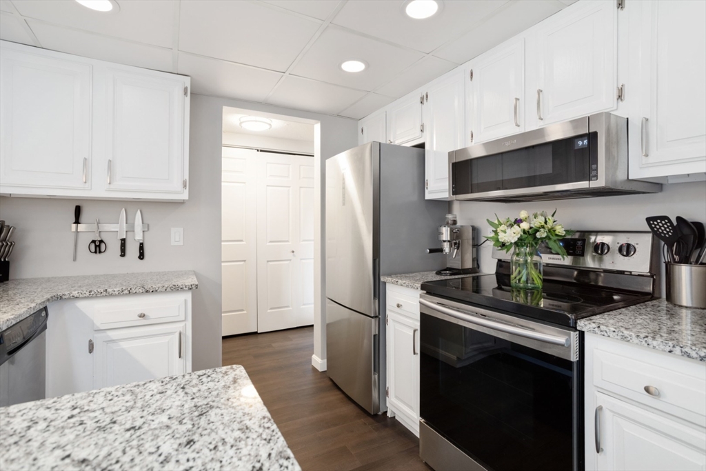 3 Ledgewood Way, Unit 8 Peabody, MA 01960 - Photo 11 of 36 a kitchen with stainless steel appliances granite countertop a refrigerator sink and stove