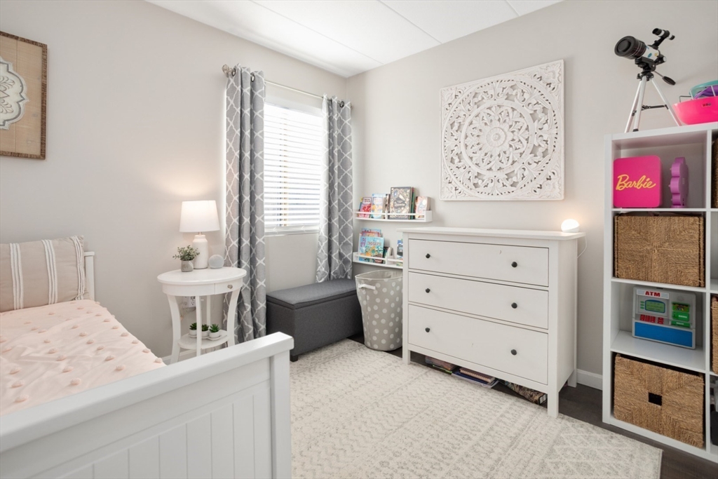 3 Ledgewood Way, Unit 8 Peabody, MA 01960 - Photo 22 of 36 a room with a baby bed baby crib and a dresser
