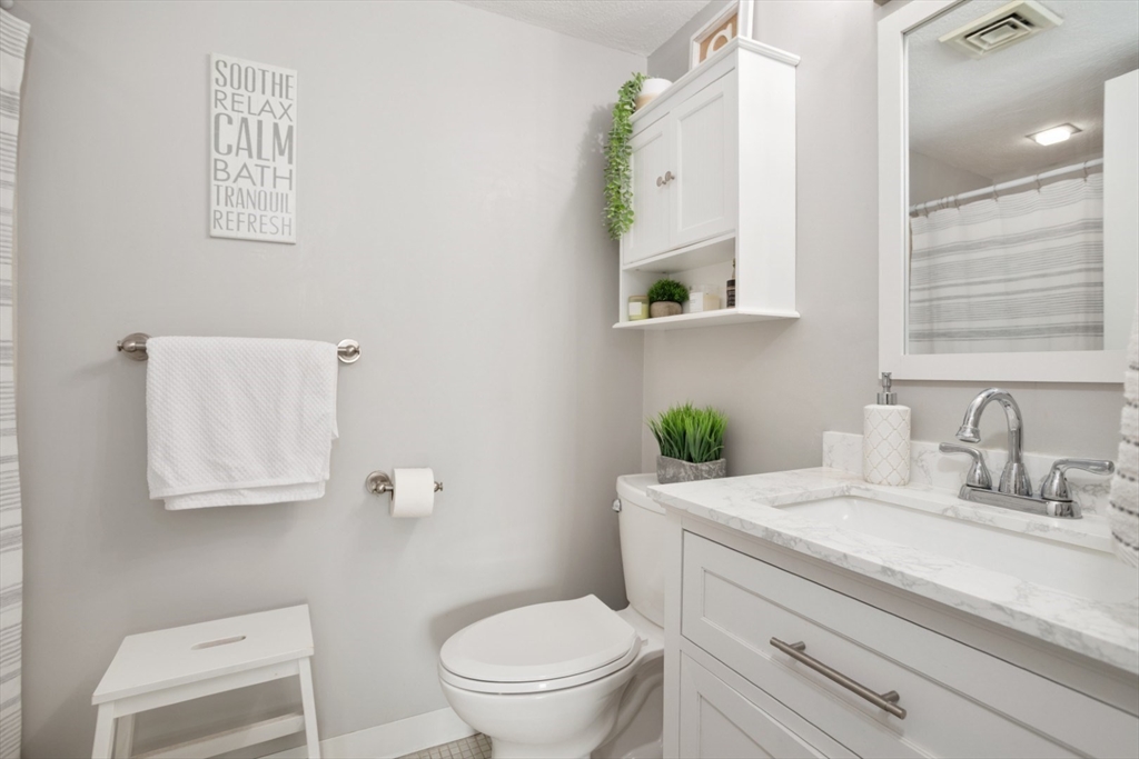 3 Ledgewood Way, Unit 8 Peabody, MA 01960 - Photo 24 of 36 a bathroom with a granite countertop toilet sink and mirror