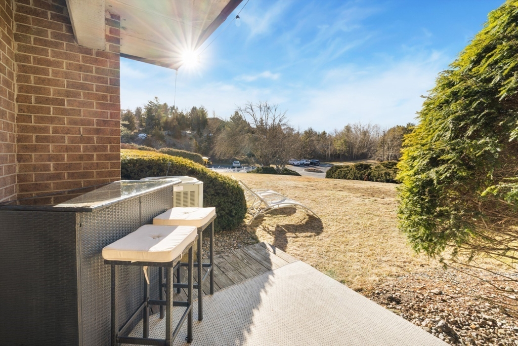 3 Ledgewood Way, Unit 8 Peabody, MA 01960 - Photo 25 of 36 a view of a balcony with table and chairs and wooden fence