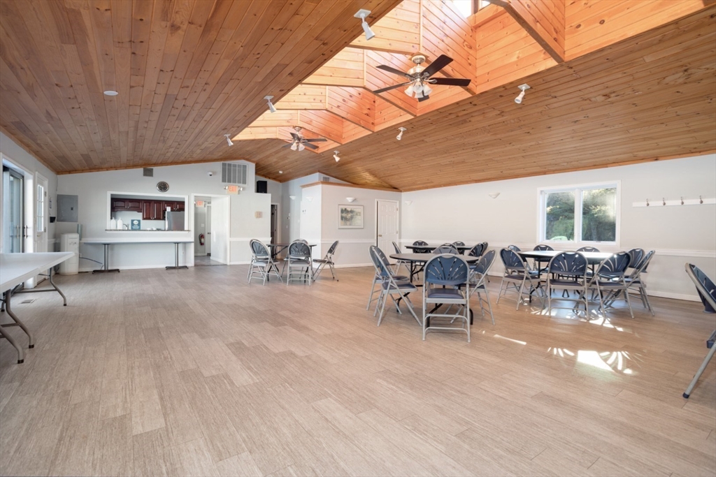 3 Ledgewood Way, Unit 8 Peabody, MA 01960 - Photo 31 of 36 a view of a patio with table and chairs with wooden floor and fence