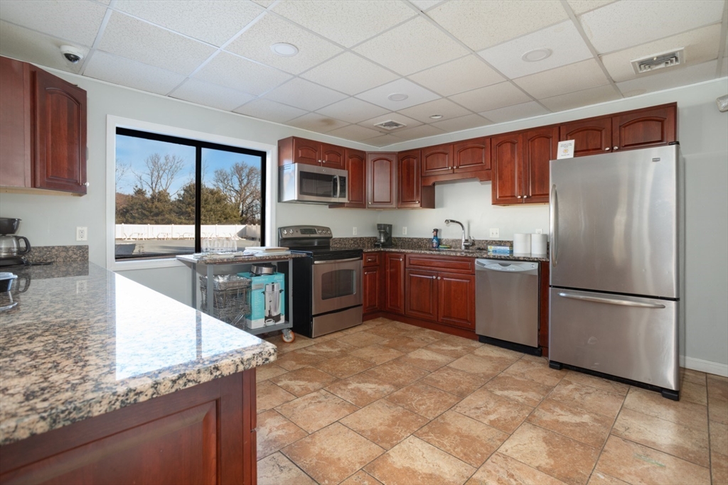 3 Ledgewood Way, Unit 8 Peabody, MA 01960 - Photo 32 of 36 a kitchen with stainless steel appliances granite countertop a stove a sink and a refrigerator