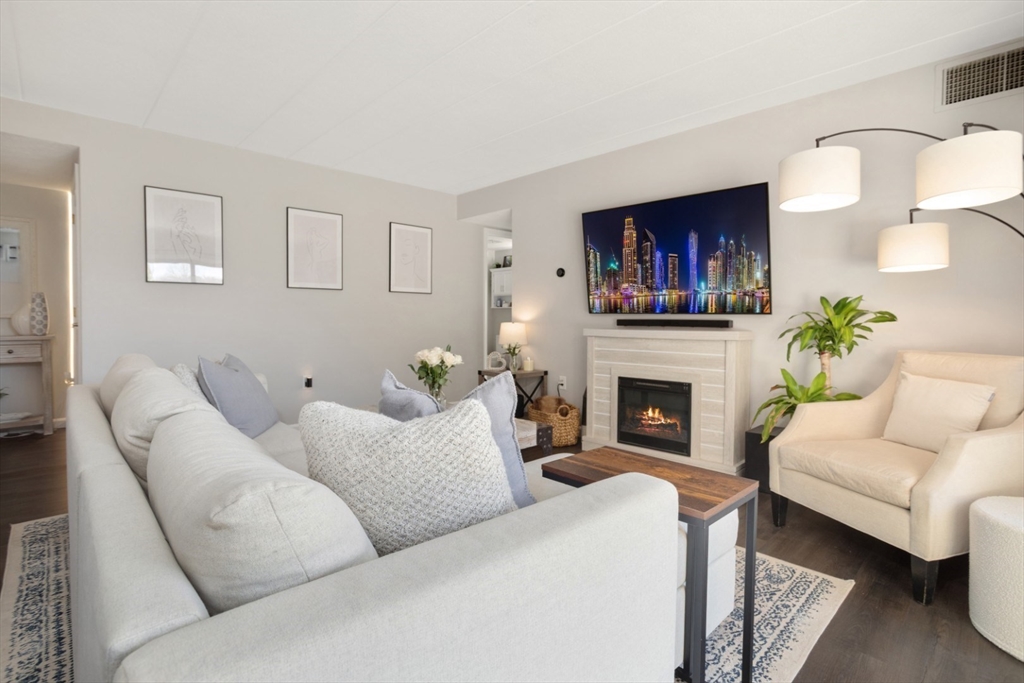 3 Ledgewood Way, Unit 8 Peabody, MA 01960 - Photo 7 of 36 a living room with furniture a fireplace and a flat screen tv