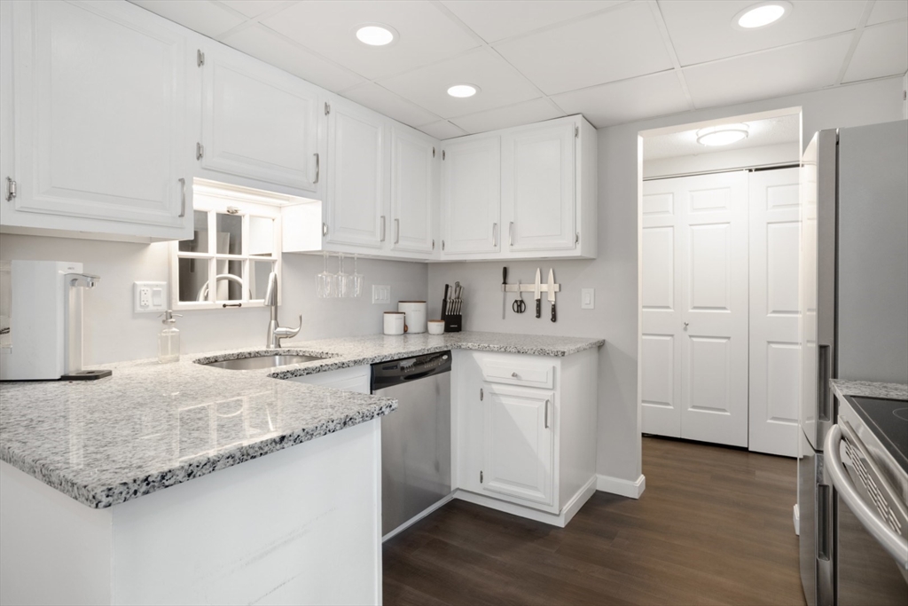 3 Ledgewood Way, Unit 8 Peabody, MA 01960 - Photo 10 of 36 a kitchen with granite countertop white cabinets and white appliances
