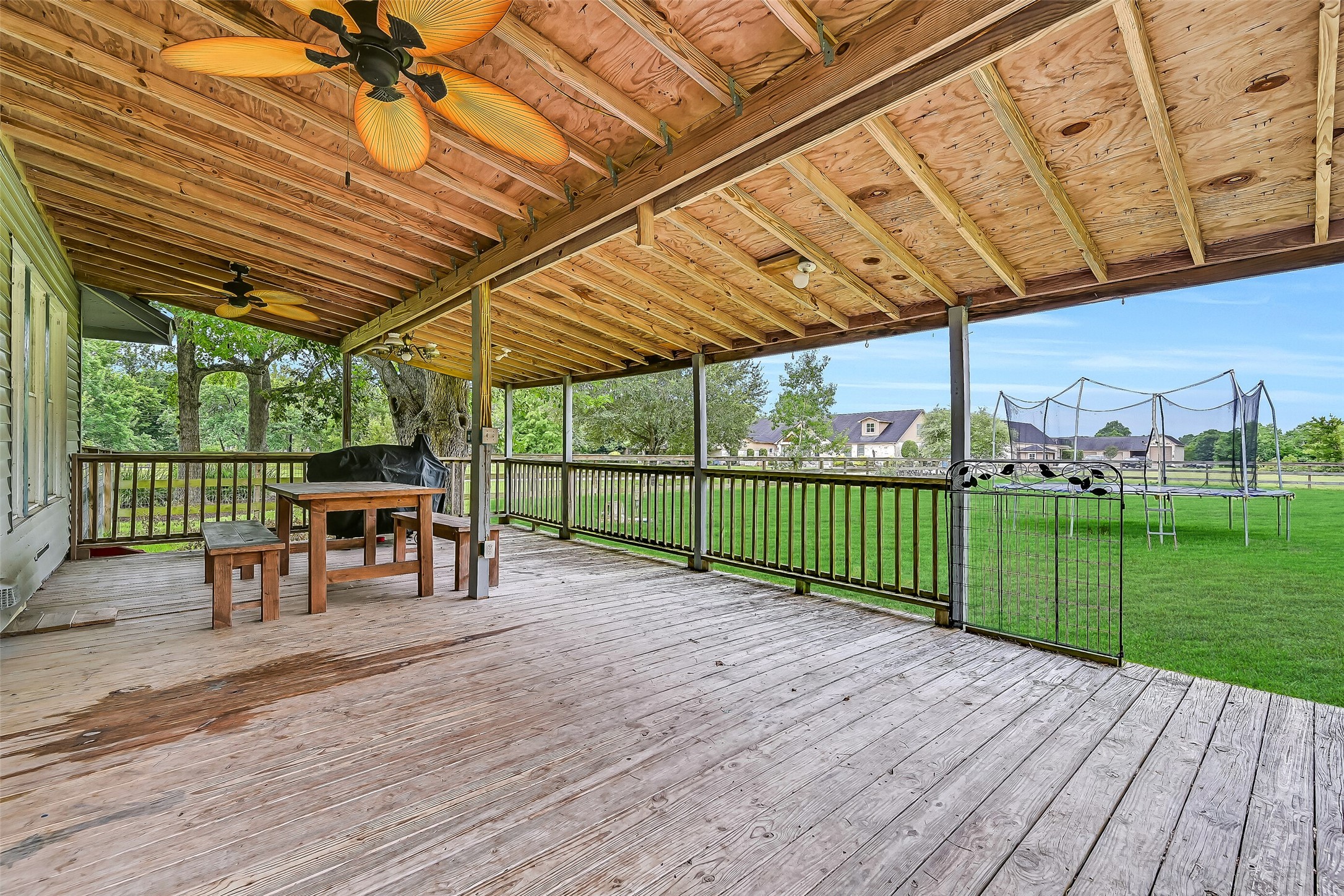 16724 Harkey Road Pearland, TX 77584 - Photo 25 of 34 The covered back porch spans the entire back of the home, with room for all types of outdoor activities. With sweeping views of the back pastures, it is peaceful and charming!