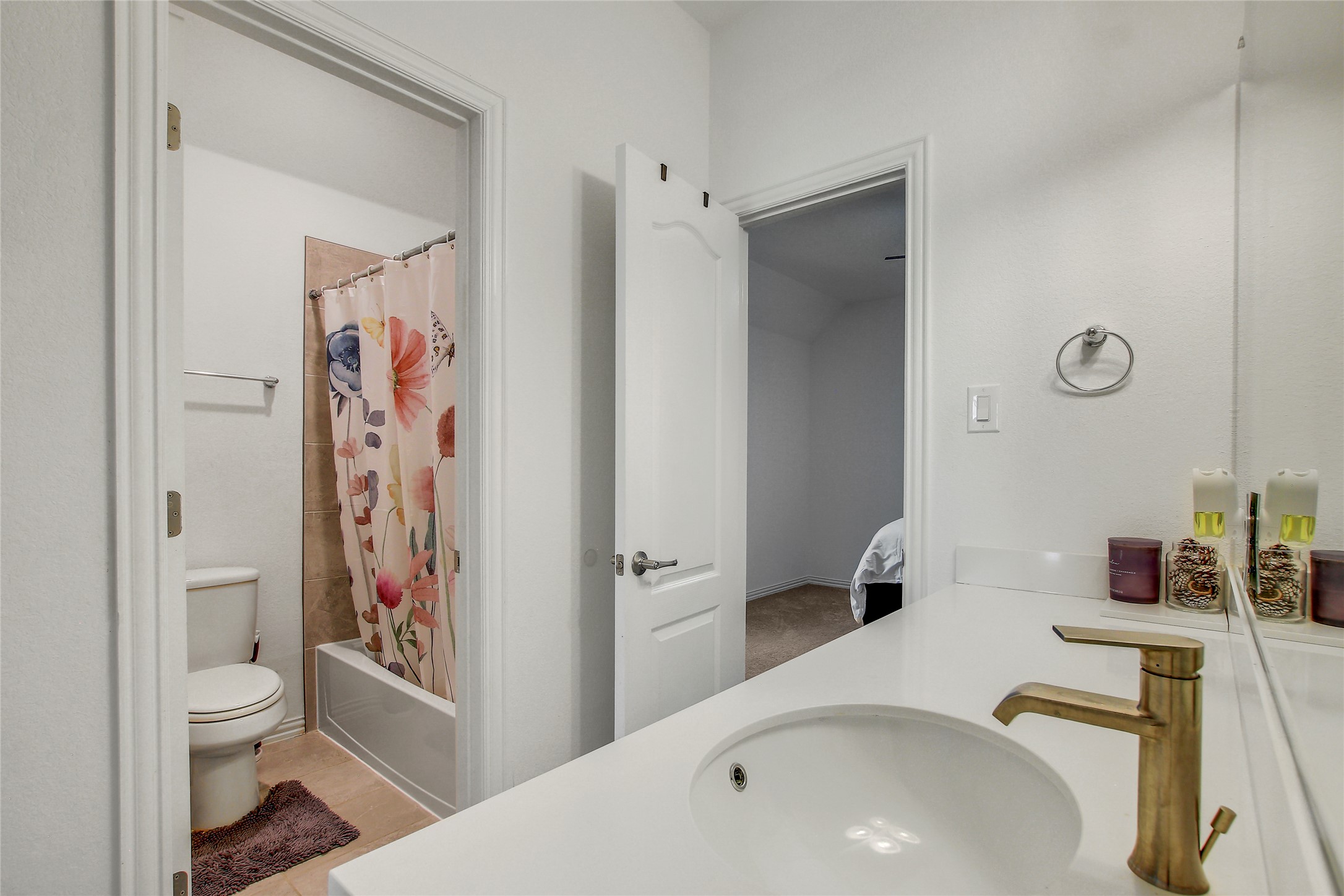 104 Millbend Road Georgetown, TX 78633 - Photo 27 of 40 A well-lit bathroom features a white vanity, modern faucet, and a shower-tub combination with tiled walls.