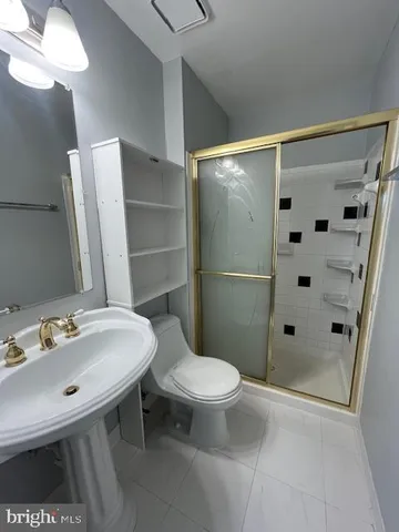 a bathroom with a sink a toilet a mirror and shower