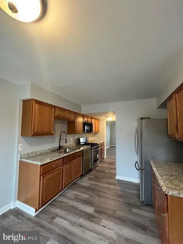a kitchen with granite countertop a sink cabinets and stainless steel appliances