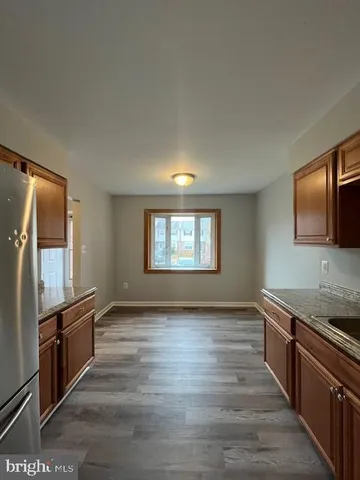 a view of a kitchen with a sink stove top oven and wooden floor
