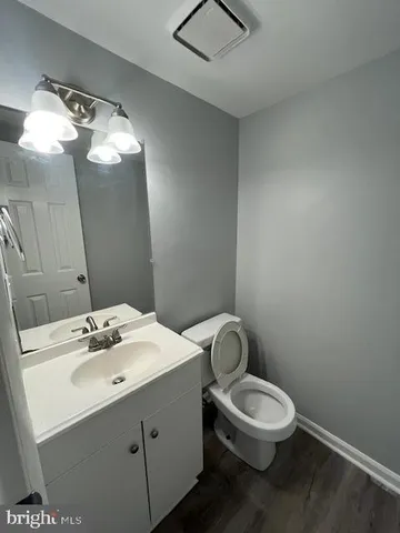 a bathroom with a sink mirror vanity and toilet
