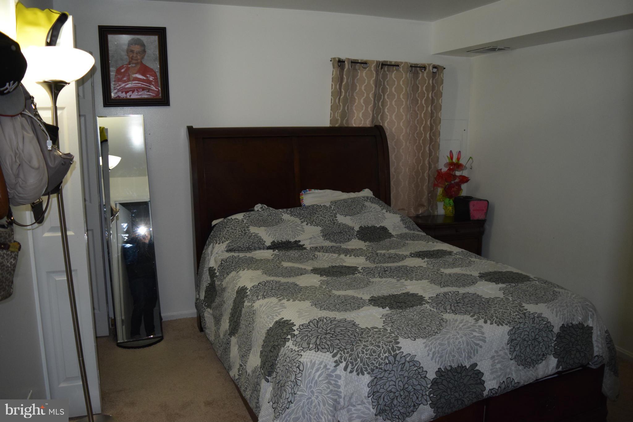 3436 Bruton Parish Way, Unit 25 Silver Spring, MD 20904 - Photo 5 of 6 a bedroom with a bed and a mirror