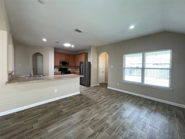 an empty room with wooden floor and windows