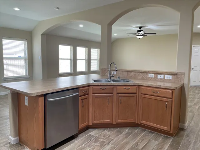 a kitchen with granite countertop cabinets stainless steel appliances a sink and a window