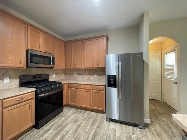 a kitchen with granite countertop a refrigerator stove and microwave