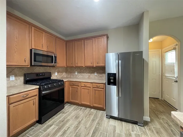 a kitchen with granite countertop a refrigerator stove and microwave
