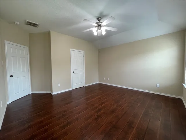 a view of an empty room with wooden floor
