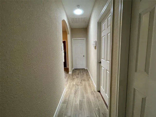 a view of a hallway with wooden floor