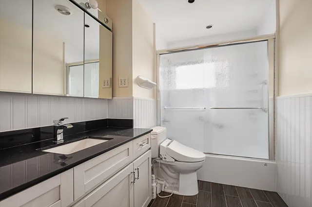 a bathroom with a granite countertop sink toilet and shower