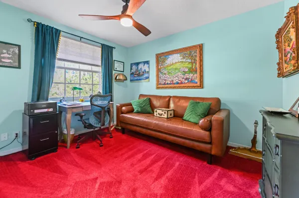 a living room with furniture a ceiling fan and a window