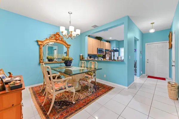 a dining room with chandelier fan and wooden floor
