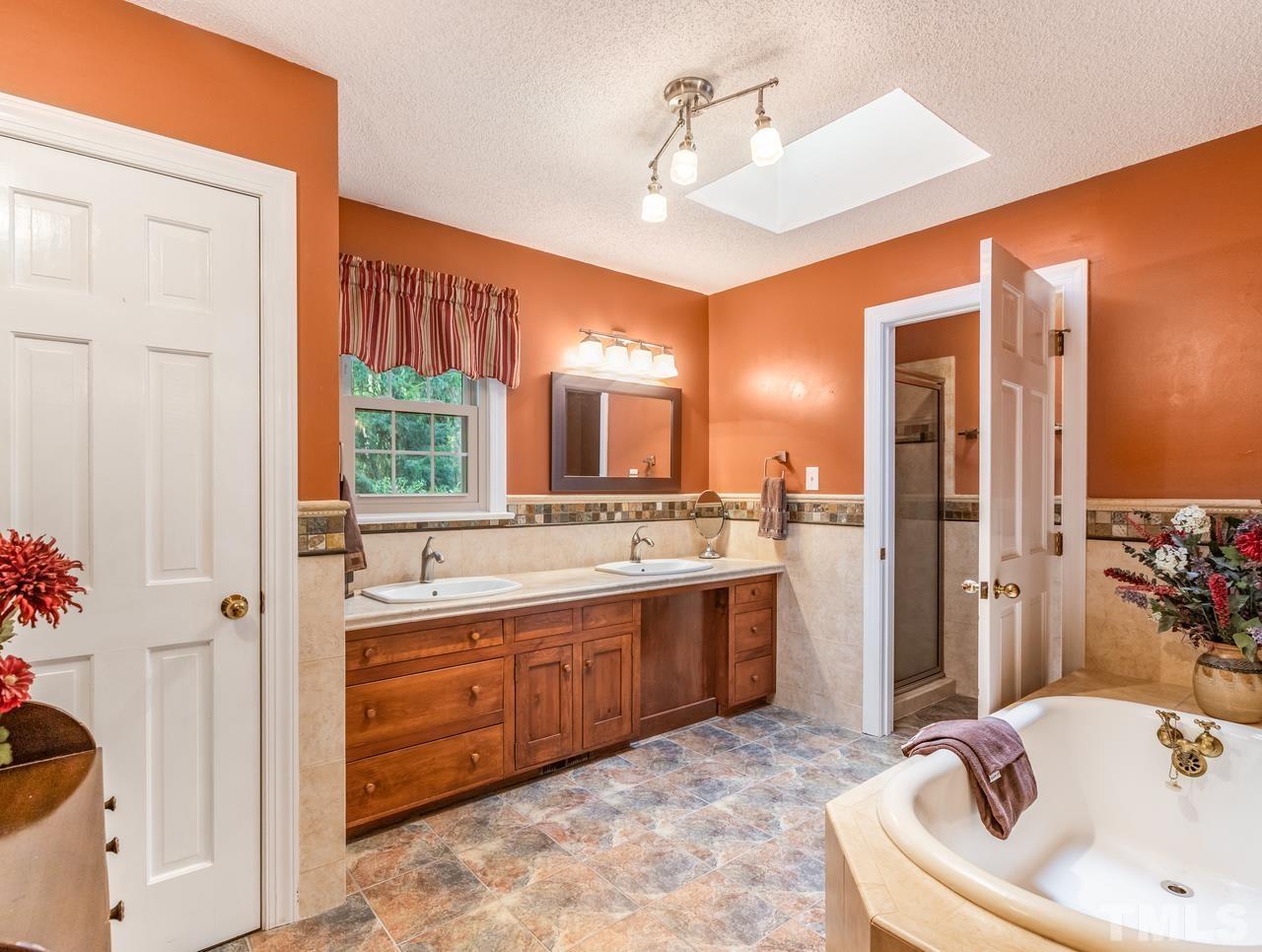 2003 Parliament Place Apex, NC 27502 - Photo 14 of 24 a bathroom with a tub sink and mirror
