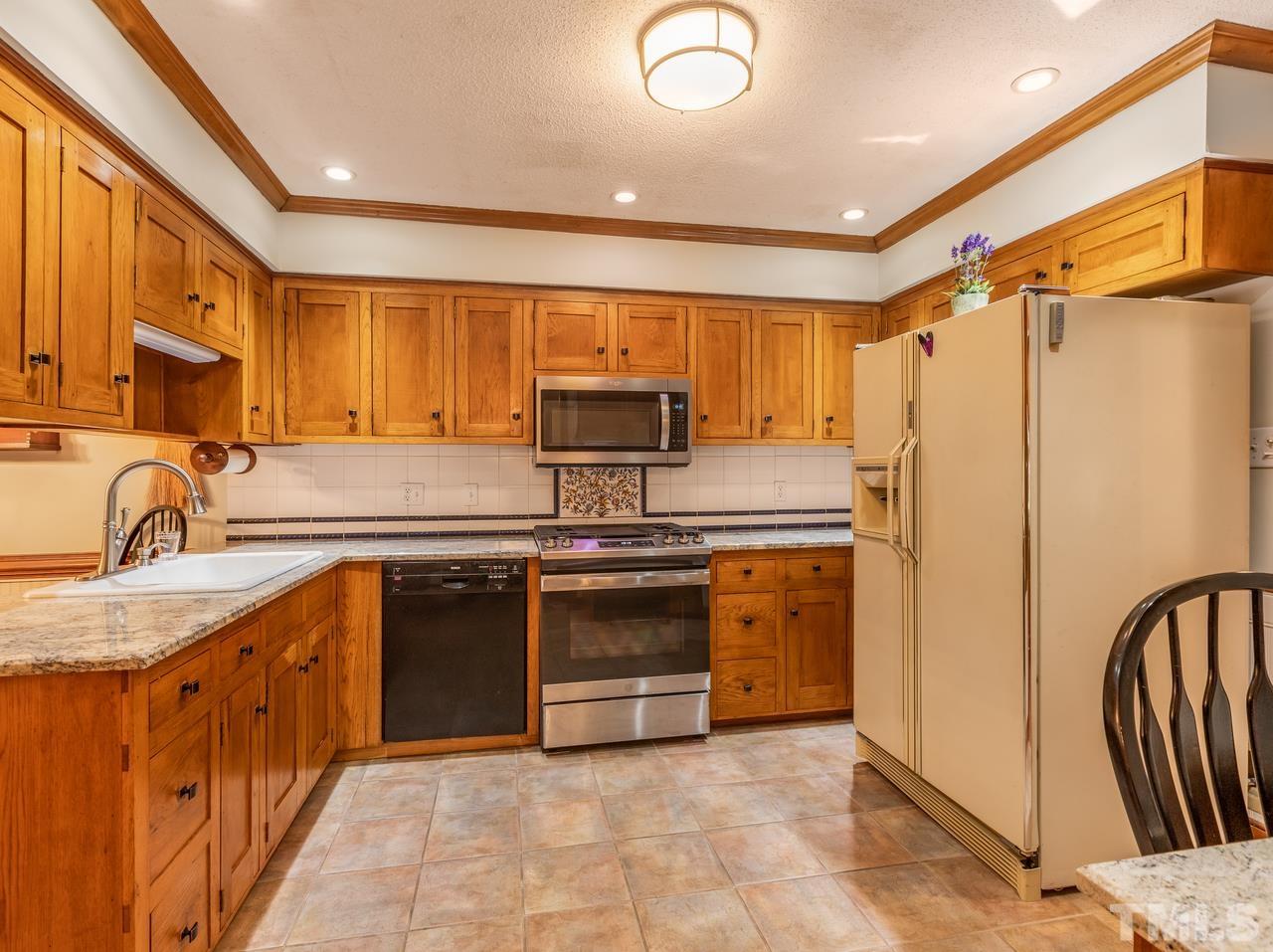 2003 Parliament Place Apex, NC 27502 - Photo 7 of 24 a kitchen with stainless steel appliances granite countertop a refrigerator and a stove top oven