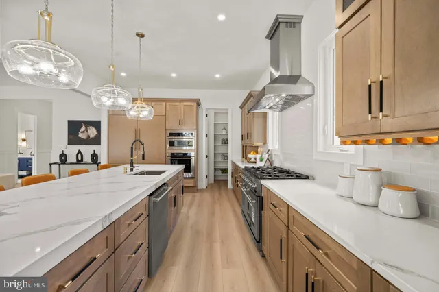 a kitchen with stainless steel appliances a sink a stove and a window