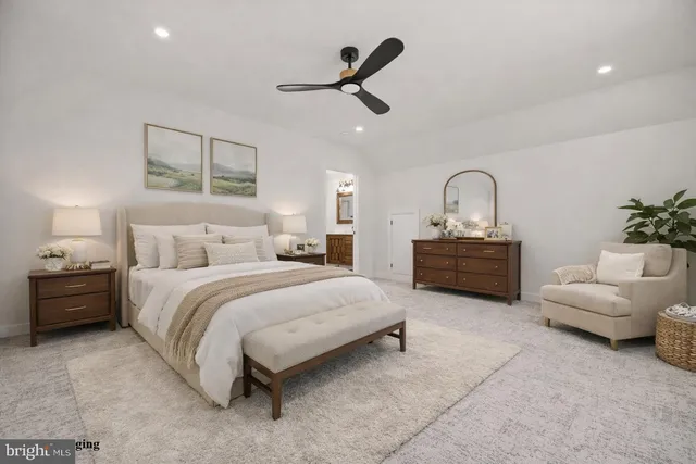 a view of an empty room with wooden floor and a kitchen