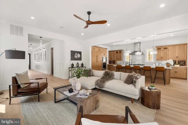 a kitchen with stainless steel appliances kitchen island granite countertop a table chairs and a refrigerator