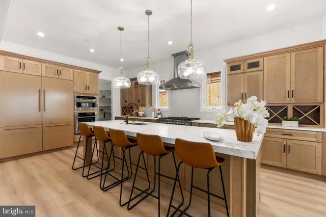 a kitchen with stainless steel appliances granite countertop a stove a sink dishwasher and a refrigerator with wooden floor