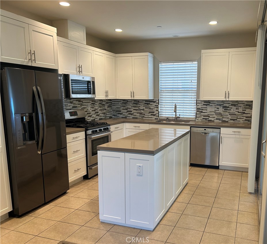 104 Briarberry Irvine, CA 92618 - Photo 9 of 27 a kitchen with stainless steel appliances granite countertop a stove a sink and a refrigerator